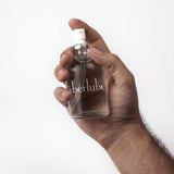 Hand holding the Überlube 112 ml glass pump bottle