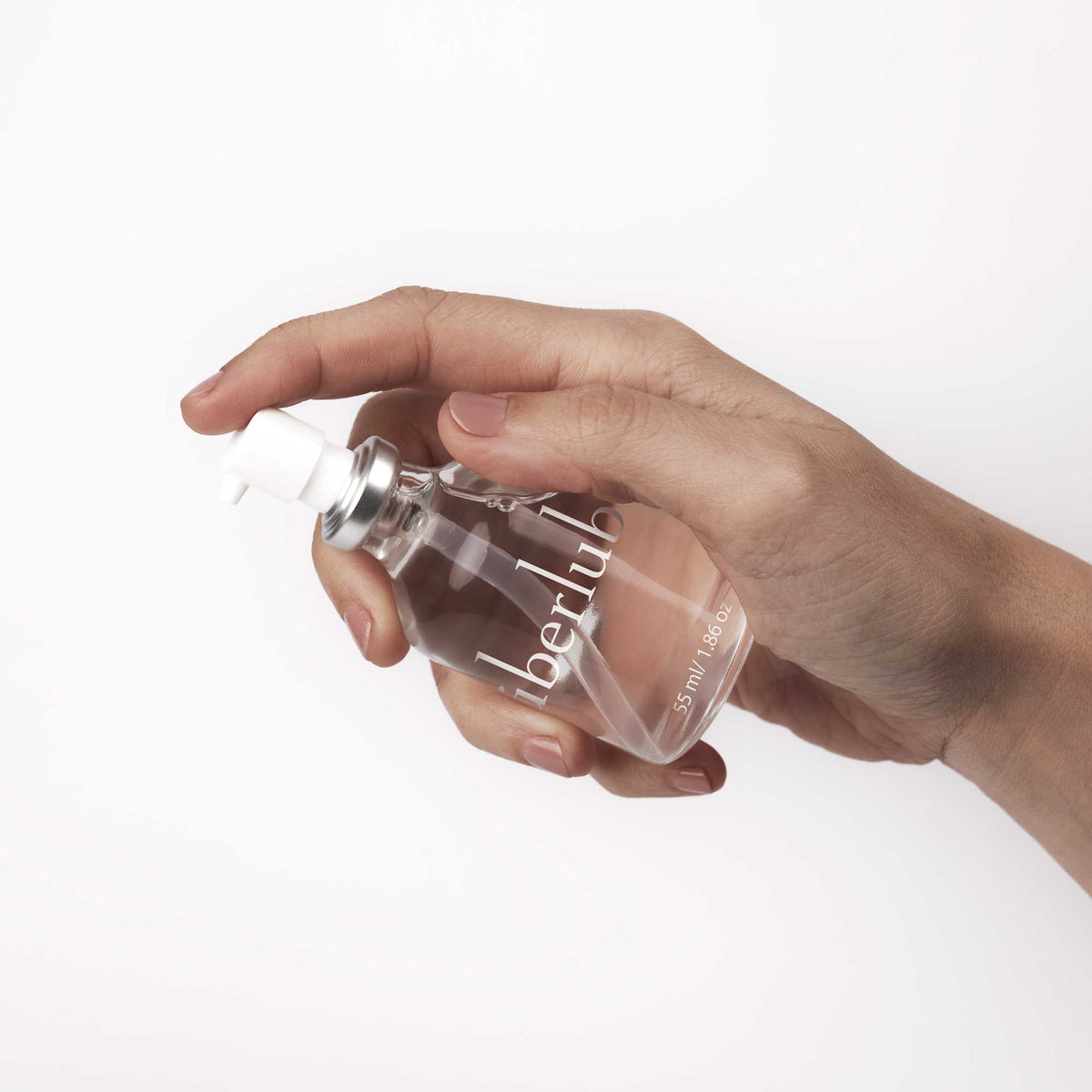 Hand holding the Überlube 55 ml glass pump bottle