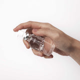 Hand holding the Überlube 55 ml glass pump bottle