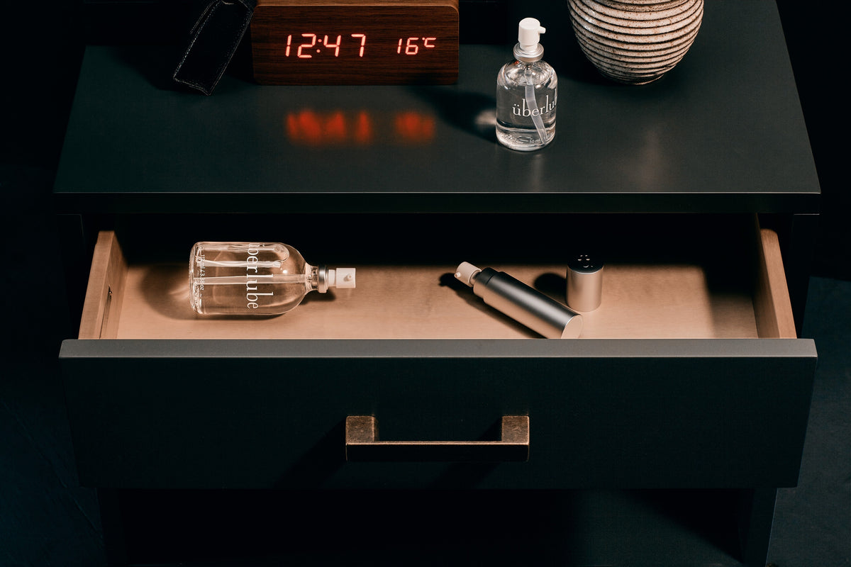 Überlube glass pump bottle on a bedside table
